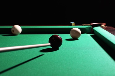 Striking red ball into billiard table pocket