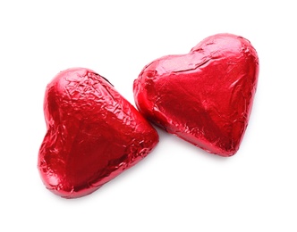 Photo of Heart shaped chocolate candies in red foil on white background, top view