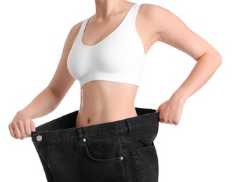 Photo of Young slim woman wearing oversized jeans on white background, closeup