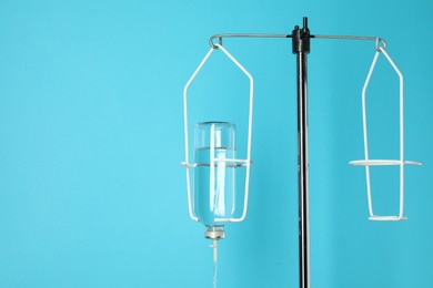 IV infusion set on pole against light blue background. Space for text