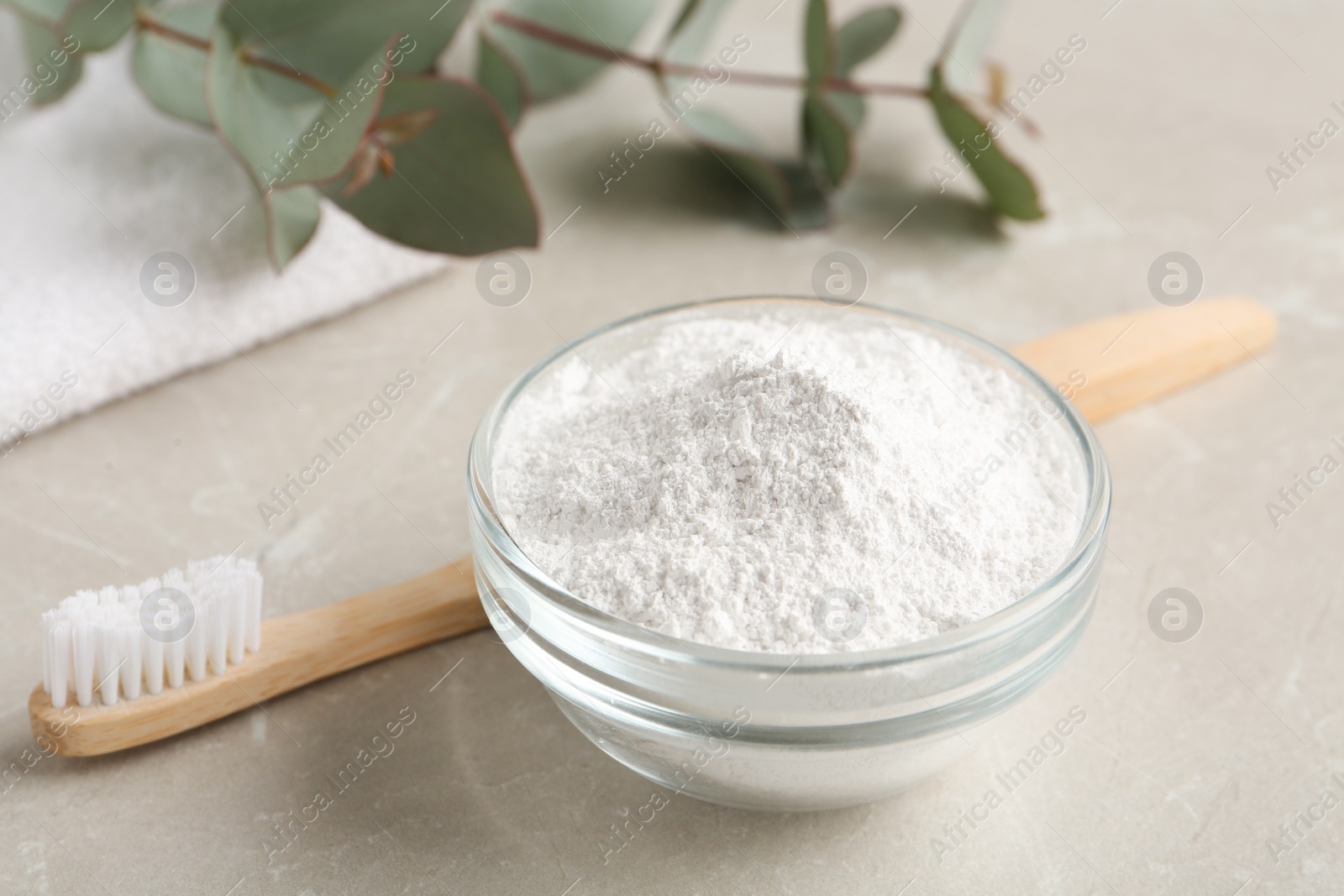 Photo of Tooth powder and brush on light grey marble table, closeup