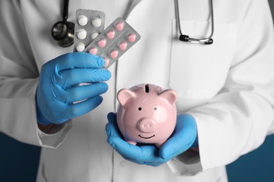 Photo of Doctor holding piggy bank and pills , closeup. Medical insurance