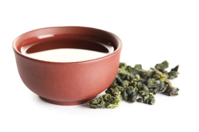 Photo of Cup of Tie Guan Yin oolong and tea leaves on white background