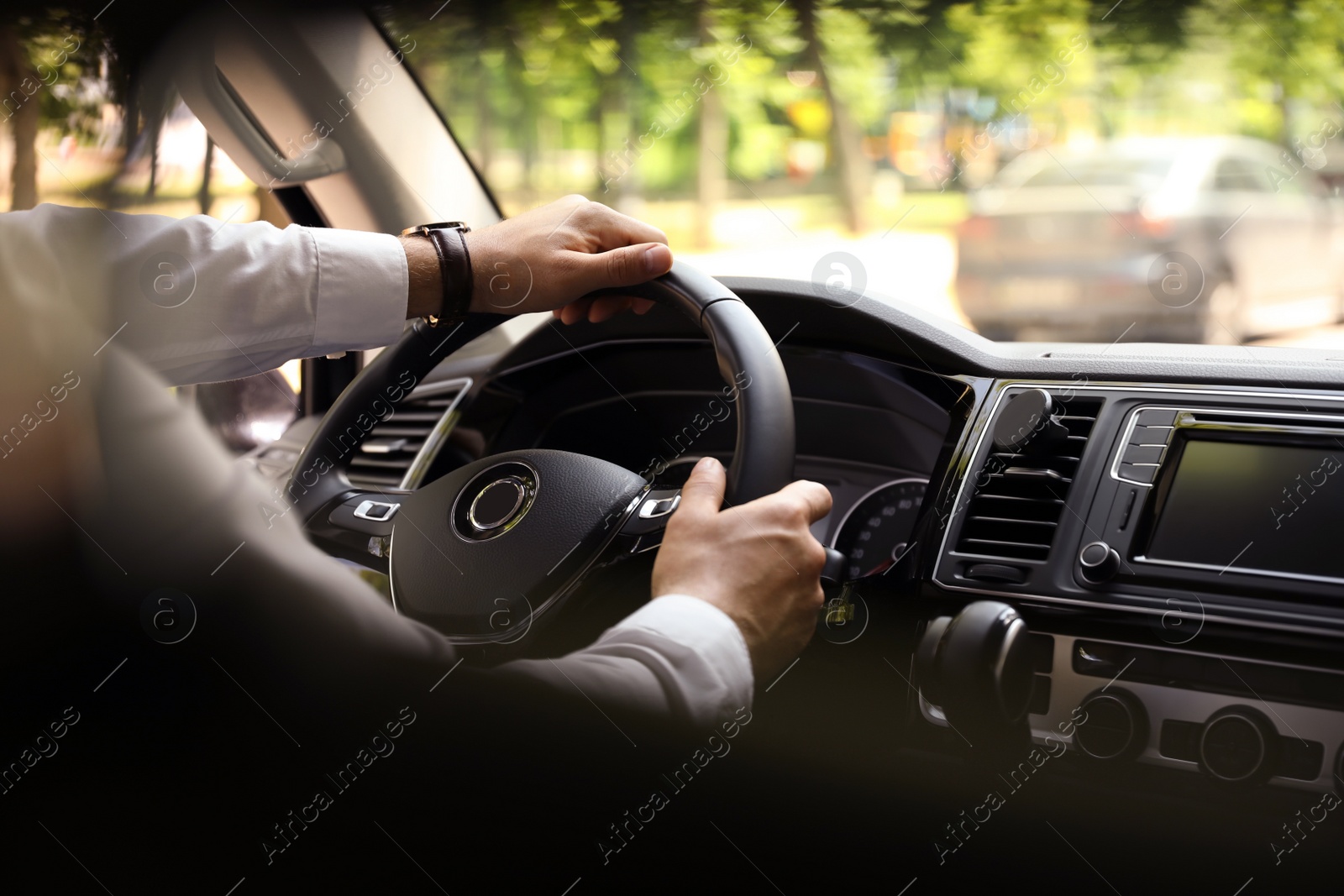 Photo of Man driving his car, closeup view of hands on steering wheel