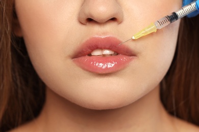 Young woman getting lips injection, closeup. Cosmetic surgery