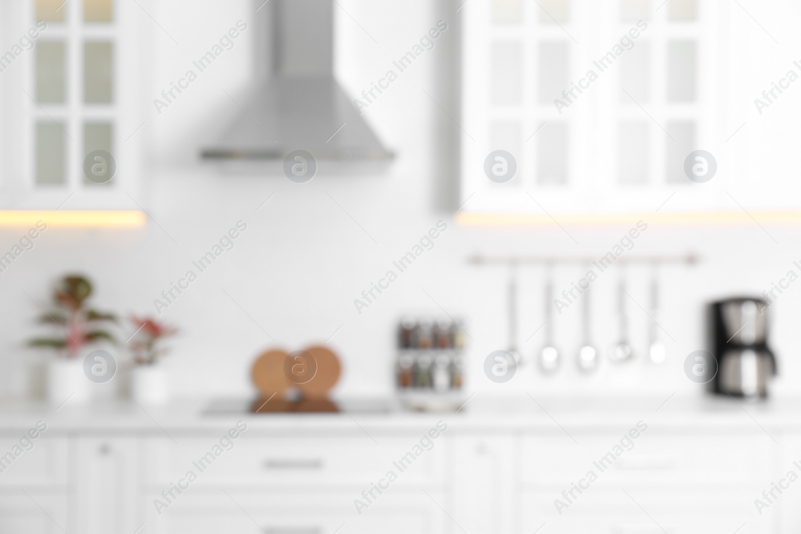 Photo of Blurred view of modern kitchen with white furniture