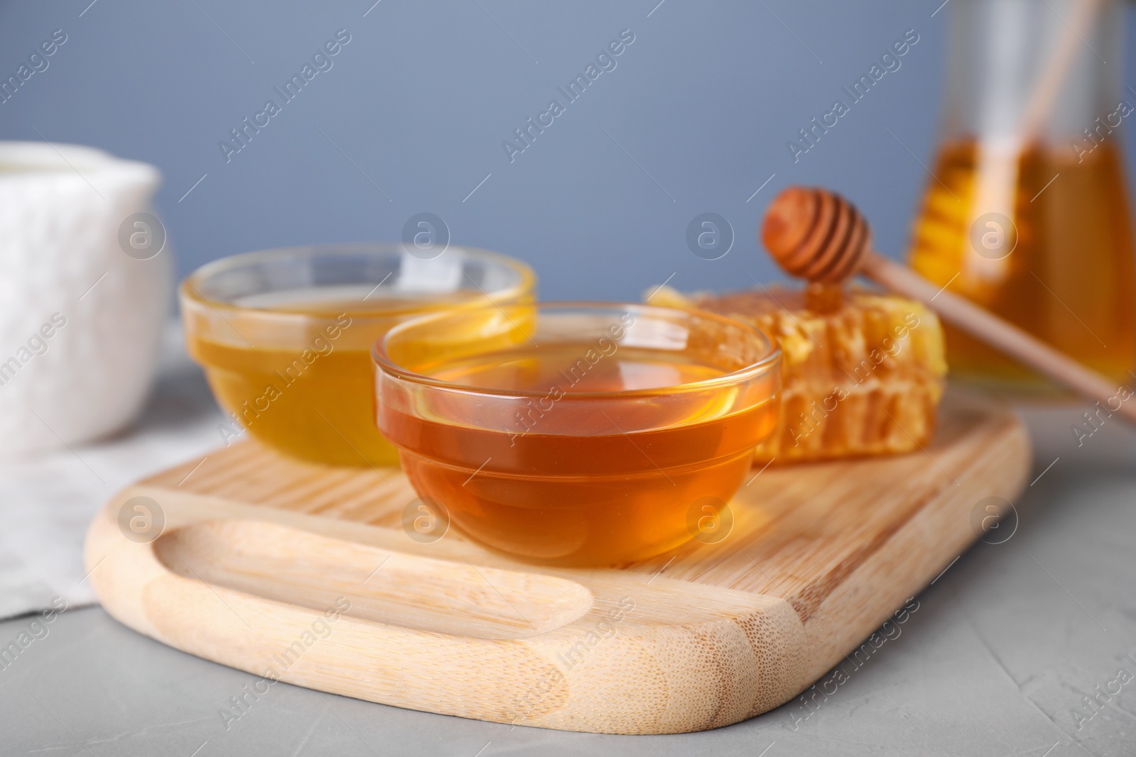 Photo of Tasty organic honey on light grey table