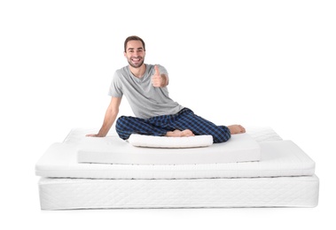 Photo of Young man sitting on mattress pile against white background