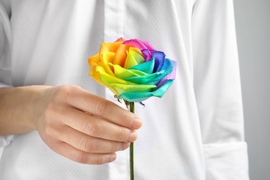 Photo of Woman holding rainbow rose flower, closeup