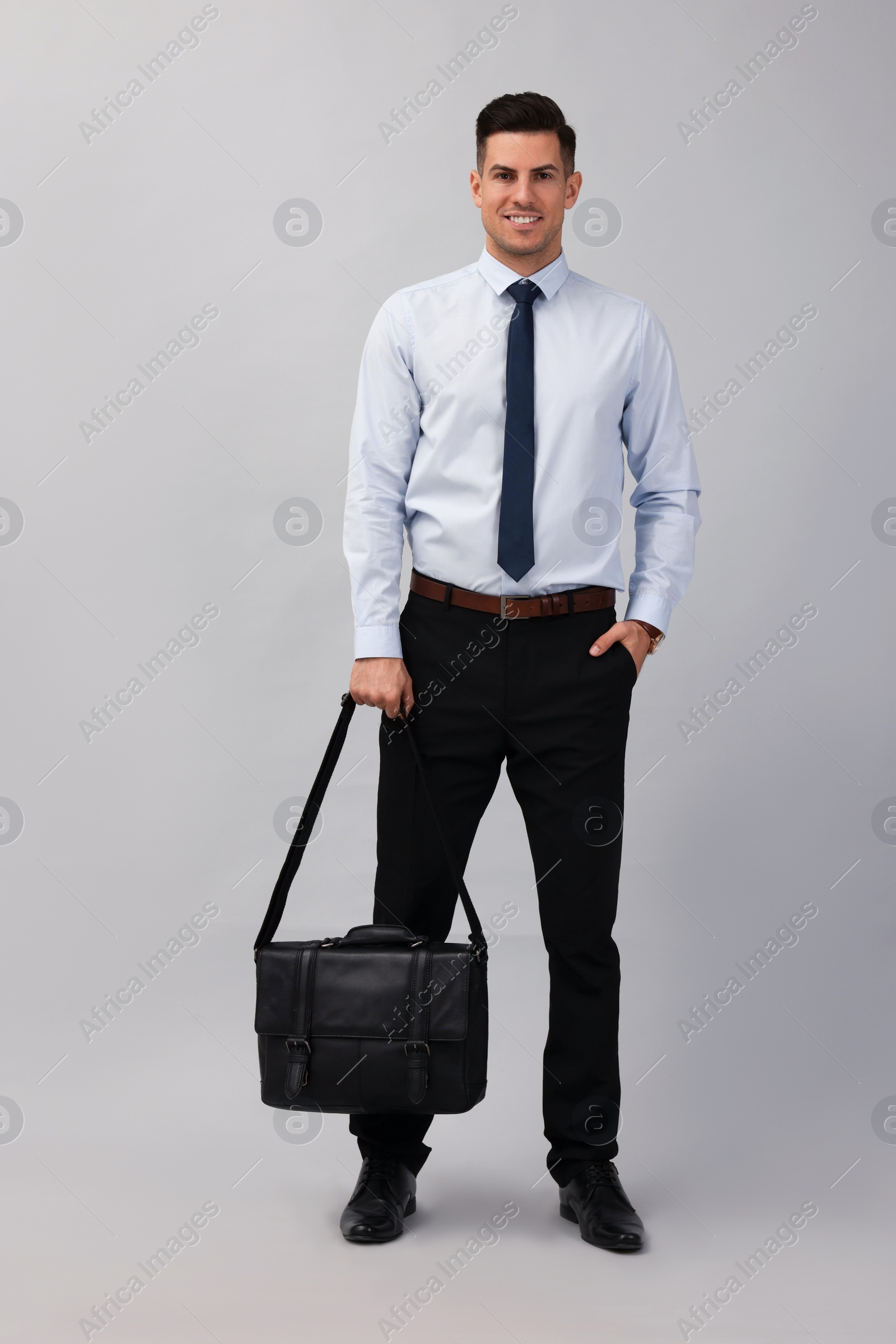 Photo of Businessman with stylish leather briefcase on light background