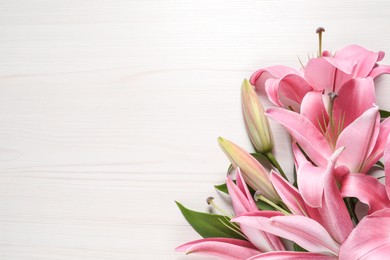 Photo of Beautiful pink lily flowers on white wooden table, top view. Space for text