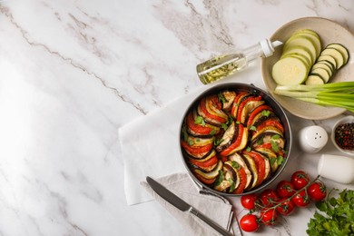 Delicious ratatouille, ingredients and knife on white marble table, flat lay. Space for text