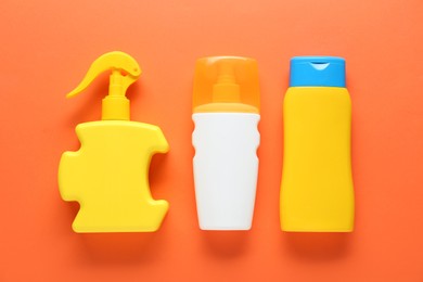 Suntan products on orange background, flat lay