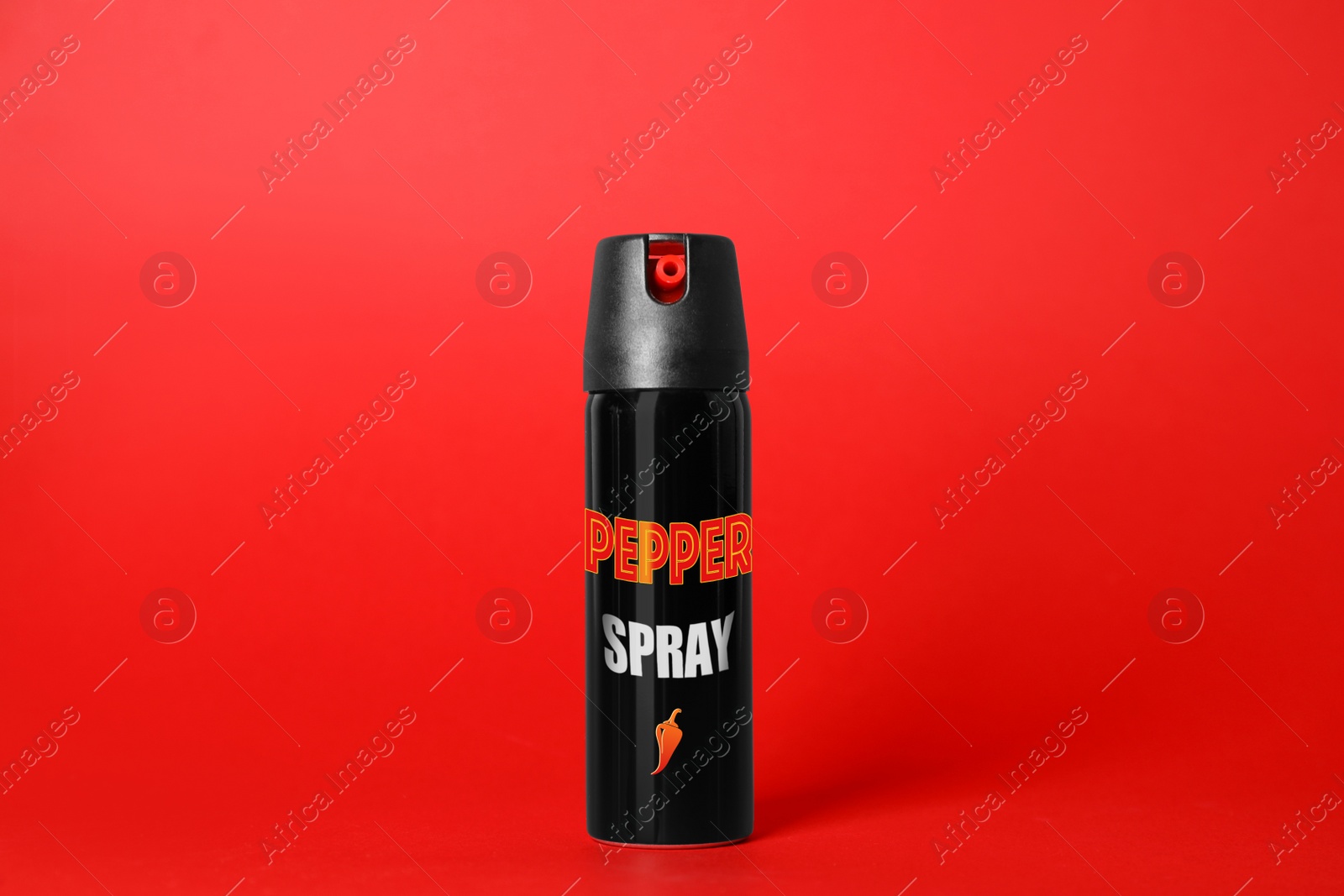 Image of Bottle of gas pepper spray on red background