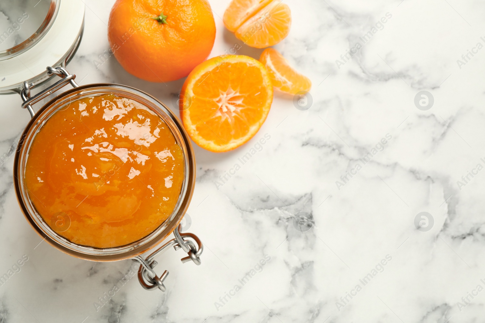 Photo of Flat lay composition with tasty tangerine jam on white marble table. Space for text