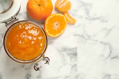 Photo of Flat lay composition with tasty tangerine jam on white marble table. Space for text