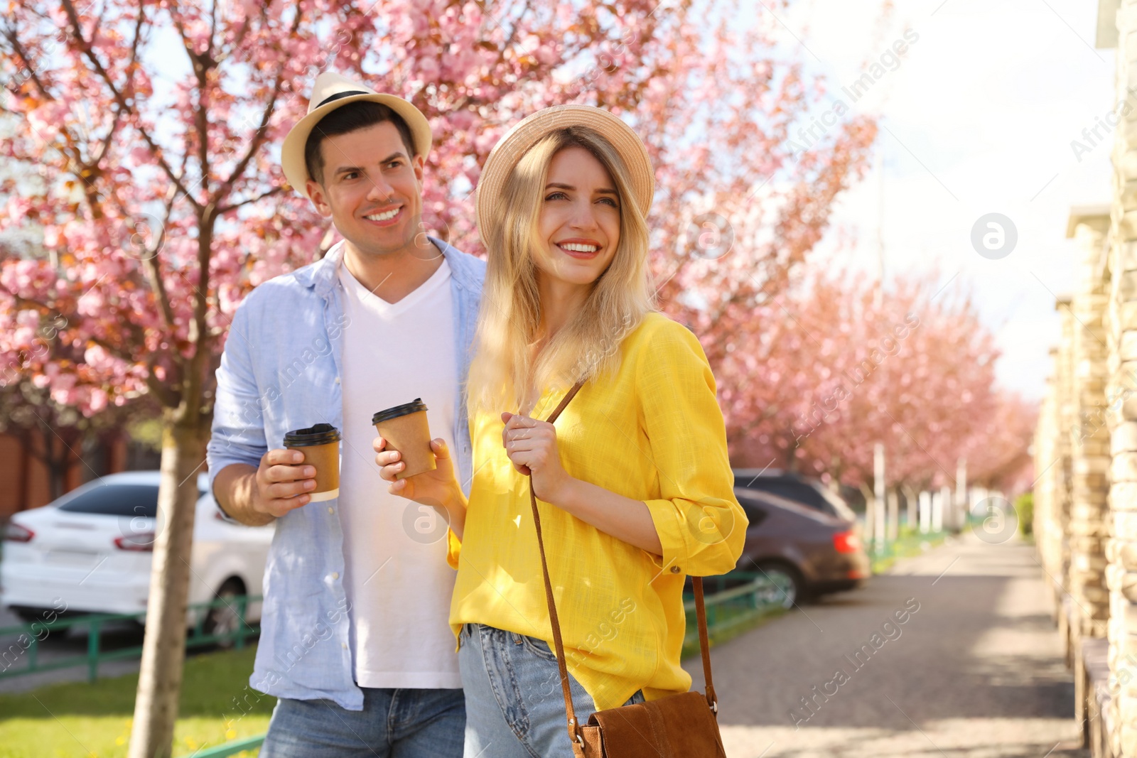 Photo of Happy couple with coffee on city street in morning