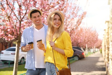 Photo of Happy couple with coffee on city street in morning