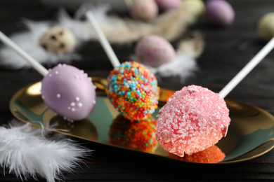 Photo of Delicious sweet cake pops on black wooden table. Easter holiday