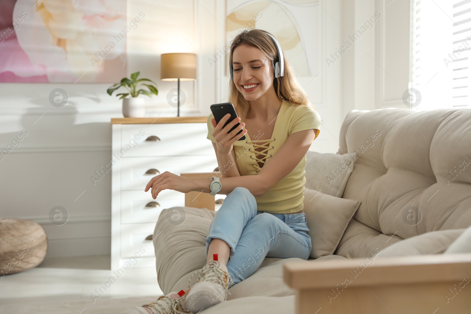 Photo of Young woman listening to music at home