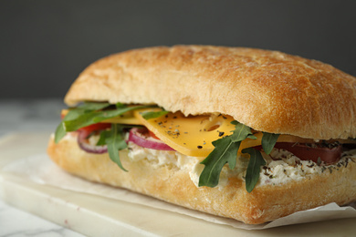 Delicious sandwich with fresh vegetables and cheese on white table, closeup