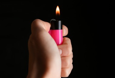 Photo of Woman holding pink lighter on black background, closeup