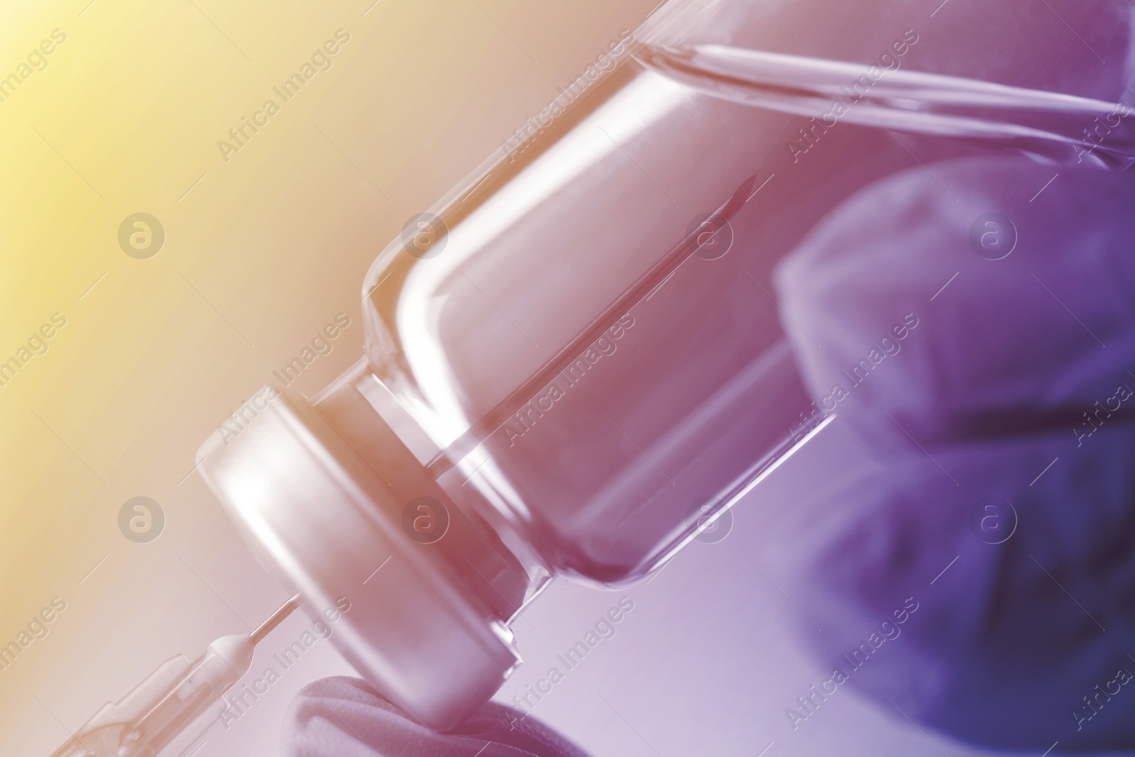 Image of Doctor filling syringe with medication from vial, closeup. Color toned