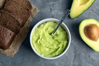 Photo of Flat lay composition with guacamole, bread and ripe avocado on grey background