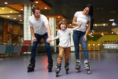 Photo of Happy family spending time at roller skating rink