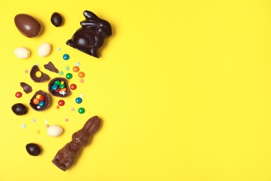 Photo of Flat lay composition with chocolate Easter eggs and space for text on color background