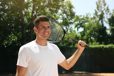 Photo of Happy man with tennis racket on court