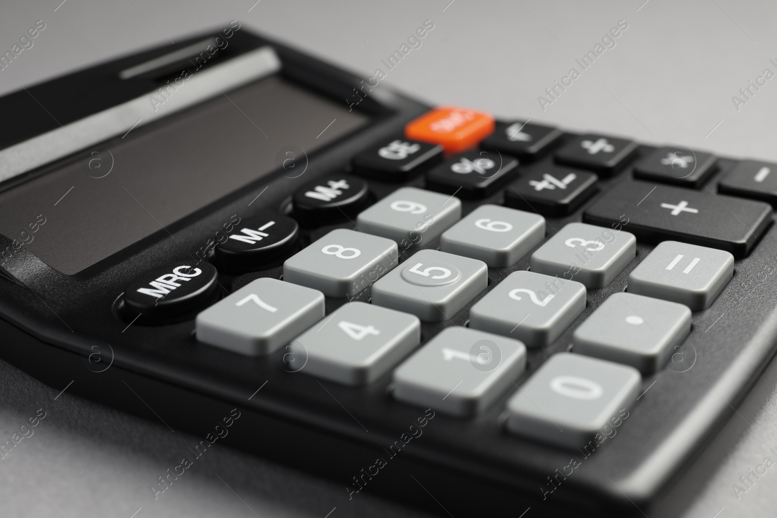 Photo of Calculator on grey background, closeup. Office stationery