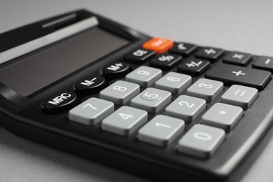 Photo of Calculator on grey background, closeup. Office stationery