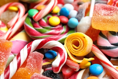 Photo of Many different yummy candies as background, closeup