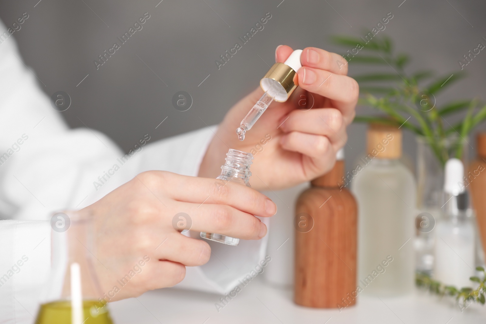 Photo of Dermatologist testing essential oil indoors, selective focus