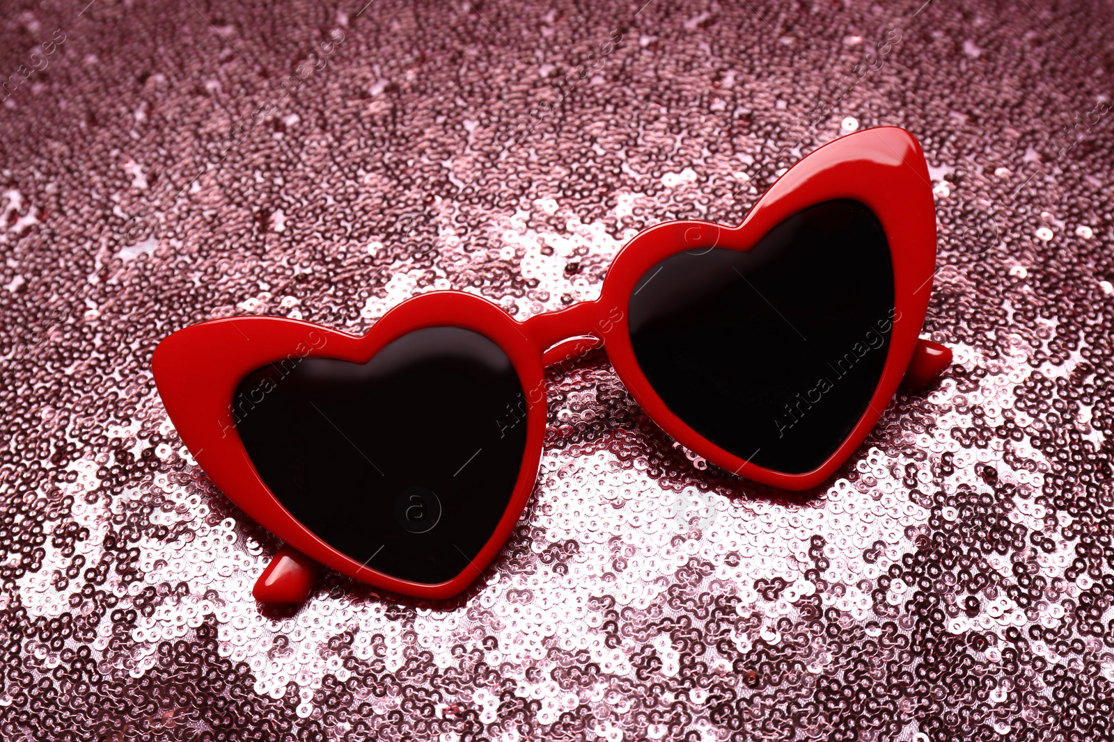 Photo of Red heart shaped sunglasses on bright background