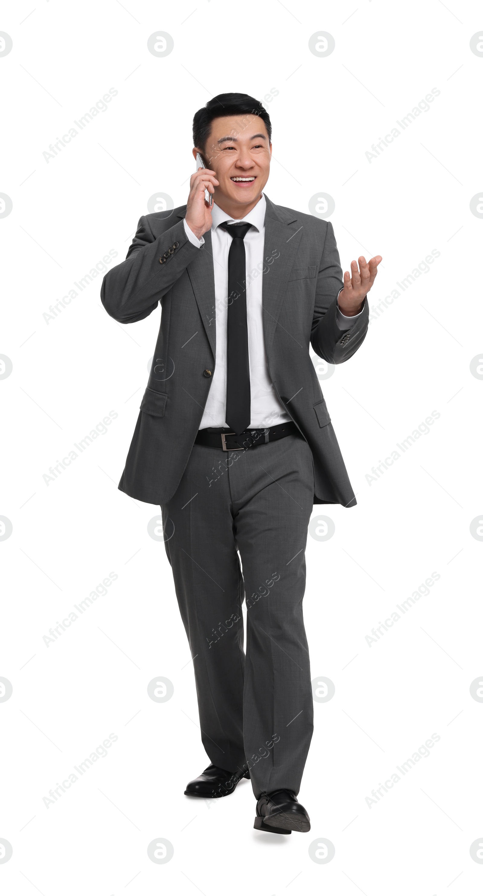 Photo of Businessman in suit talking on phone against white background