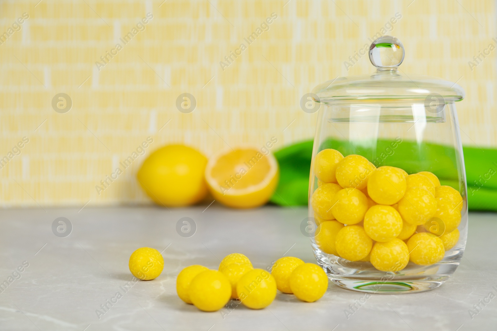 Photo of Delicious lemon drops on grey table. Space for text