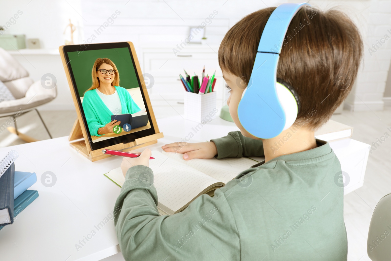 Image of E-learning. Little boy using tablet for studying online at table indoors