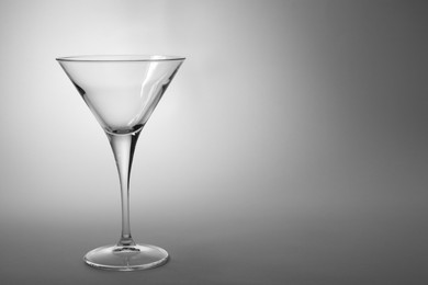Photo of Elegant empty martini glass on grey background. Space for text
