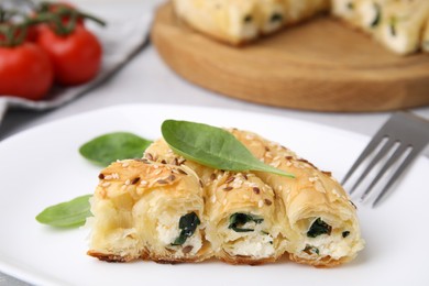 Photo of Piece of delicious puff pastry with spinach on table, closeup