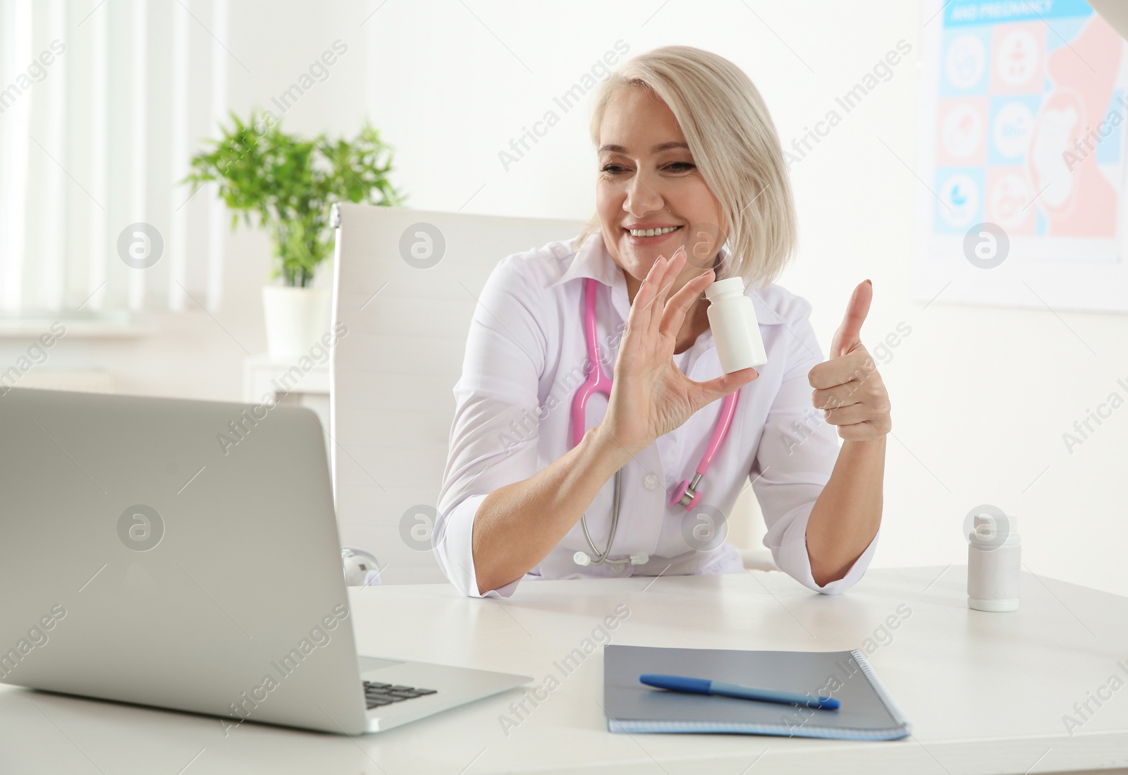 Photo of Doctor consulting patient using video chat on laptop in clinic