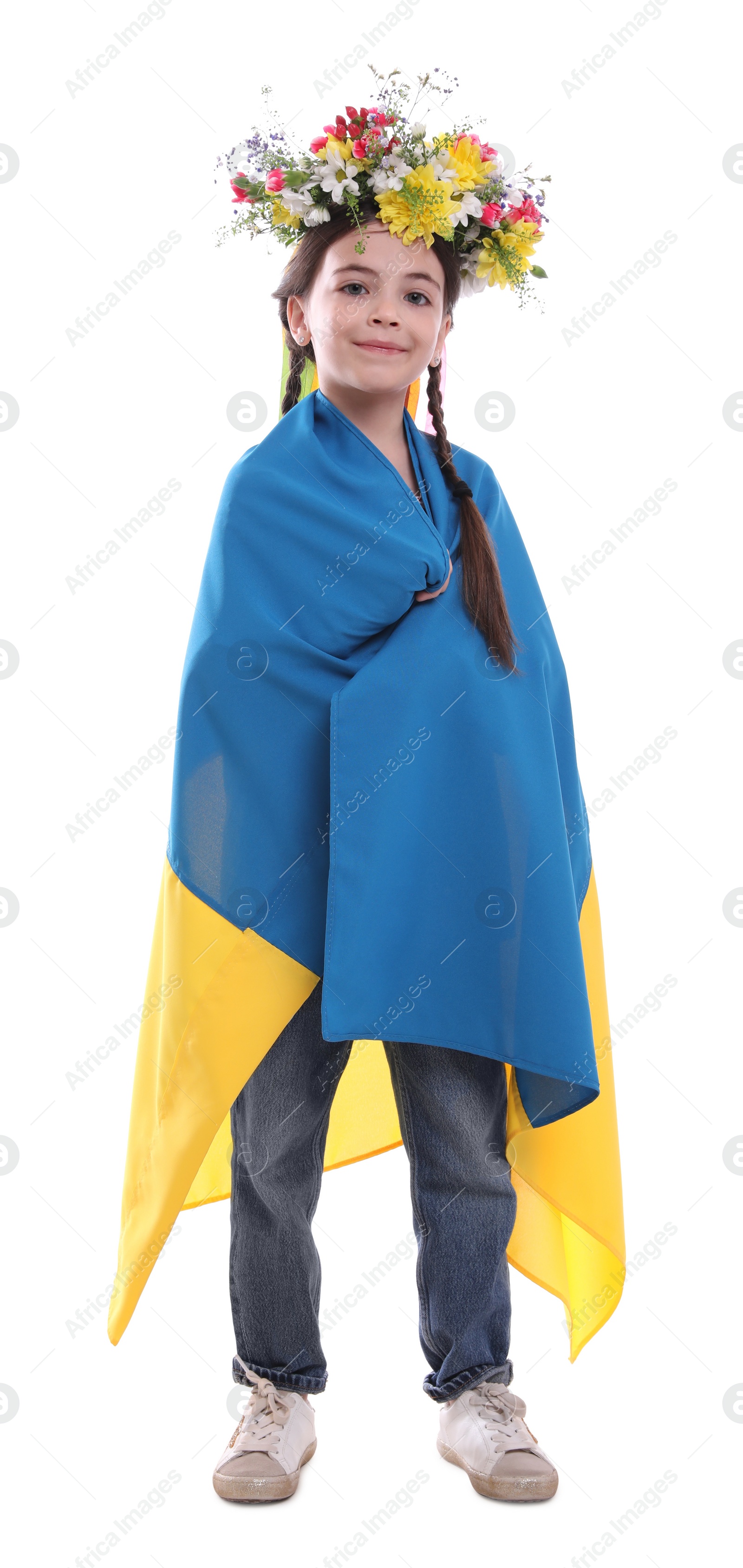 Photo of Little girl in flower wreath with flag of Ukraine on white background