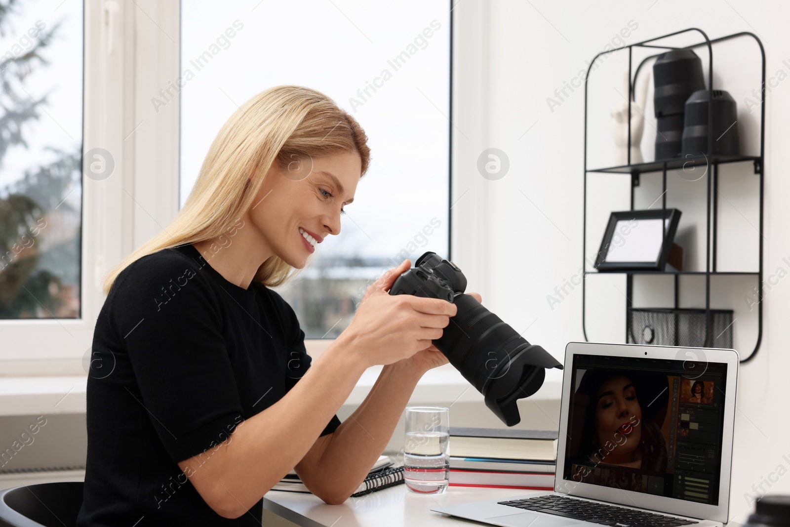 Photo of Professional photographer with digital camera at table in office