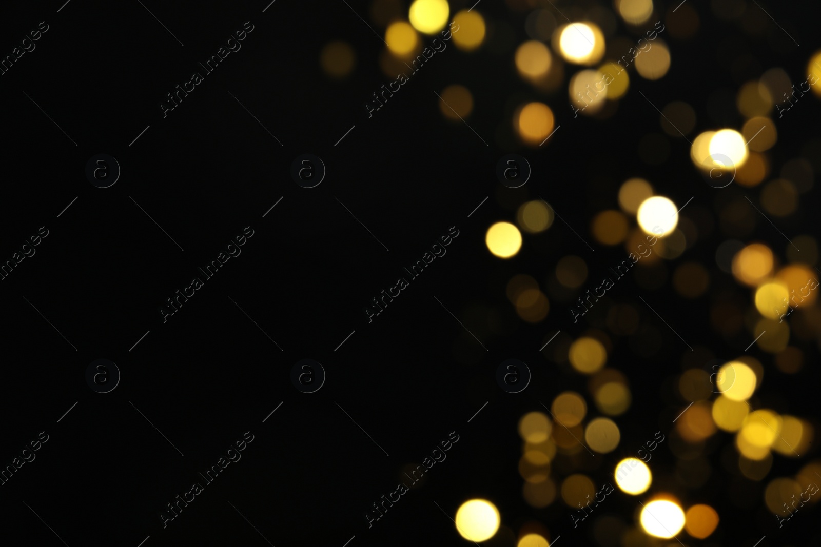 Photo of Blurred view of golden lights on black background, space for text. Bokeh effect