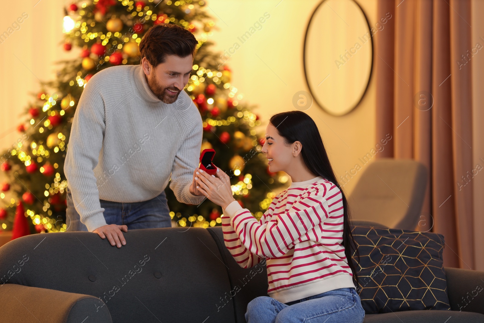 Photo of Man with engagement ring making proposal to his girlfriend at home on Christmas