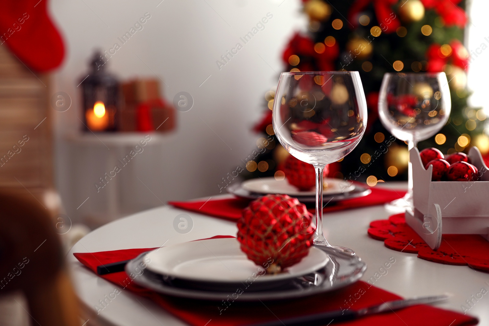 Photo of Festive table setting and Christmas tree in stylish room interior