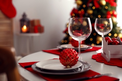 Photo of Festive table setting and Christmas tree in stylish room interior