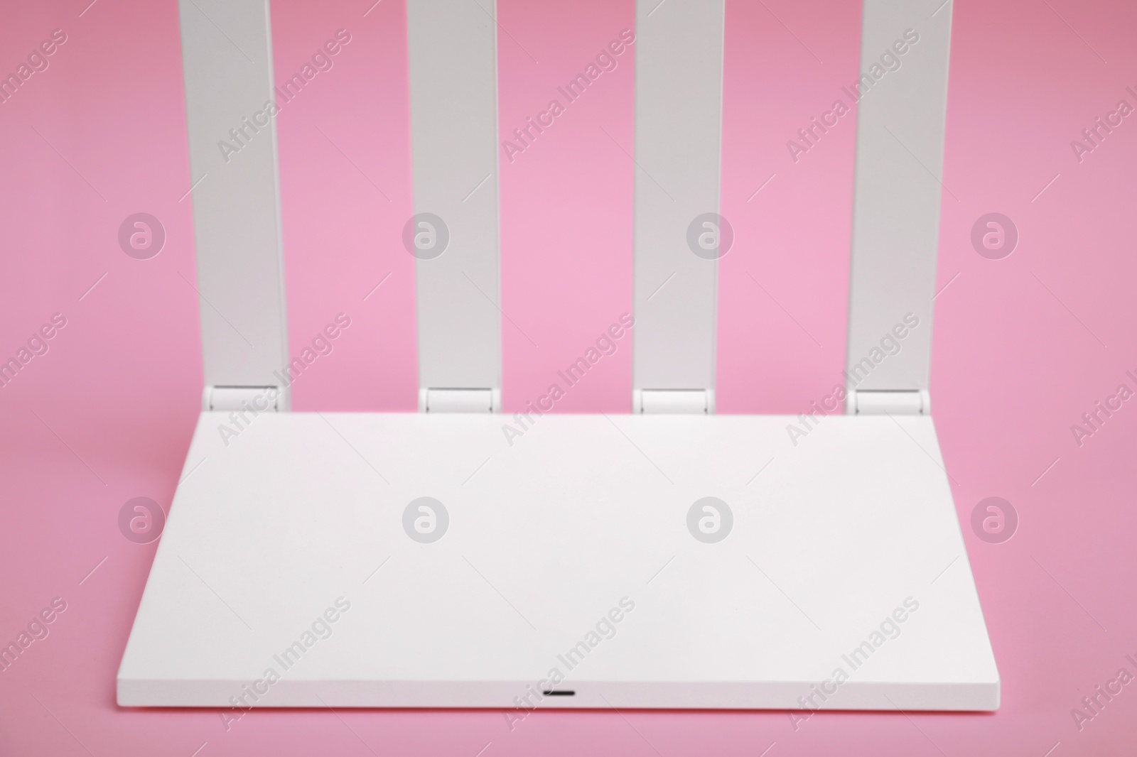 Photo of One modern Wi-Fi router on pink background