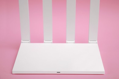 Photo of One modern Wi-Fi router on pink background